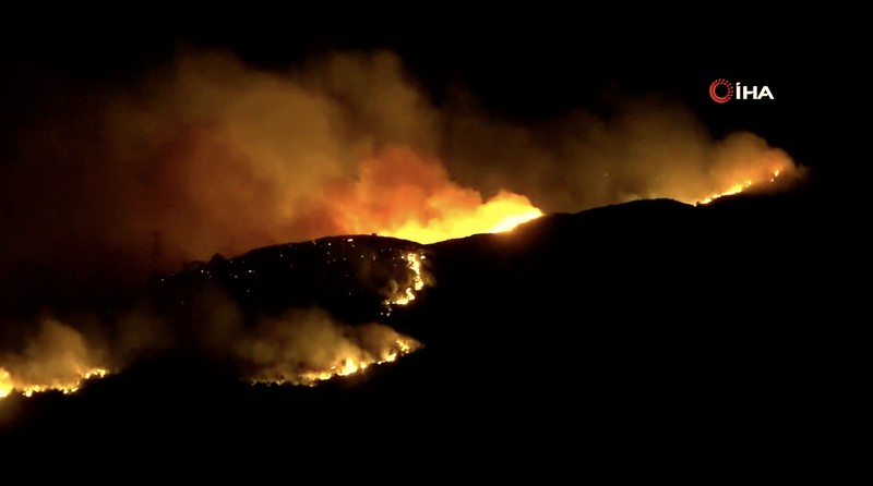 Kebakaran hutan melanda dekat rumah-rumah di Hatay, Turki pada Senin malam (30 Juni), dan warga dievakuasi menurut keterangan pejabat. Kebakaran hutan melanda dekat rumah-rumah di Hatay, Turki pada Senin malam (30 Juni), dan warga dievakuasi menurut keterangan pejabat. (Tangkapan Layar Video Reuters/IHA)