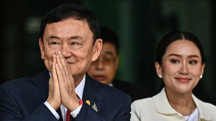 Mantan Perdana Menteri Thailand Thaksin Shinawatra menyapa para pendukungnya bersama putri bungsunya Paetongtarn Shinawatra (Kanan) setelah mendarat di bandara Don Mueang Bangkok pada 22 Agustus 2023.(Photo by Lillian SUWANRUMPHA / AFP/File Foto)