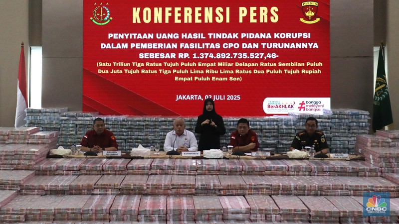 Petugas berjaga di samping tumpukan uang yang menjadi barang bukti uang sitaan saat konferensi pers kasus korupsi ekspor crude palm oil (CPO) di Gedung Bundar Jampidus Kejaksaaan Agung (Kejagung), Jakarta, Rabu (2/7/2025). (CNBC Indonesia/Muhammad Sabki) Petugas berjaga di samping tumpukan uang yang menjadi barang bukti uang sitaan saat konferensi pers kasus korupsi ekspor crude palm oil (CPO) di Gedung Bundar Jampidus Kejaksaaan Agung (Kejagung), Jakarta, Rabu (2/7/2025). (CNBC Indonesia/Muhammad Sabki)