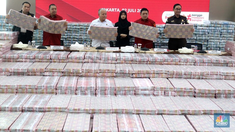 Petugas berjaga di samping tumpukan uang yang menjadi barang bukti uang sitaan saat konferensi pers kasus korupsi ekspor crude palm oil (CPO) di Gedung Bundar Jampidus Kejaksaaan Agung (Kejagung), Jakarta, Rabu (2/7/2025). (CNBC Indonesia/Muhammad Sabki) Petugas berjaga di samping tumpukan uang yang menjadi barang bukti uang sitaan saat konferensi pers kasus korupsi ekspor crude palm oil (CPO) di Gedung Bundar Jampidus Kejaksaaan Agung (Kejagung), Jakarta, Rabu (2/7/2025). (CNBC Indonesia/Muhammad Sabki)