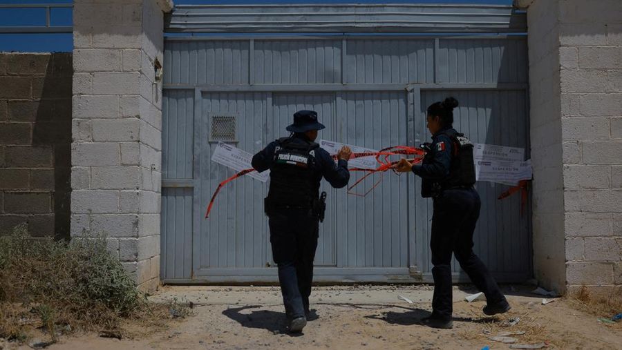 Petugas polisi menutup krematorium tempat pihak berwenang menemukan mayat-mayat yang ditumpuk dalam kondisi tidak bersih, setelah rumah duka setempat menyewa layanannya untuk kremasi, menurut Kantor Kejaksaan Negara Bagian Chihuahua, di Ciudad Juarez, Meksiko, 30 Juni 2025. (REUTERS/Jose Luis Gonzalez)