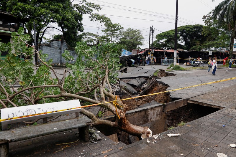 Seorang pria menjaga barang-barang miliknya di jalan setelah hujan lebat di Villavicencio, Kolombia, 1 Juli 2025. (REUTERS/Santiago Molina Fernandez)