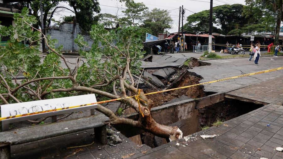 Seorang pria menjaga barang-barang miliknya di jalan setelah hujan lebat di Villavicencio, Kolombia, 1 Juli 2025. (REUTERS/Santiago Molina Fernandez)