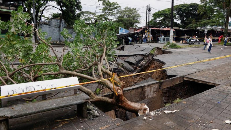 Seorang pria menjaga barang-barang miliknya di jalan setelah hujan lebat di Villavicencio, Kolombia, 1 Juli 2025. (REUTERS/Santiago Molina Fernandez)