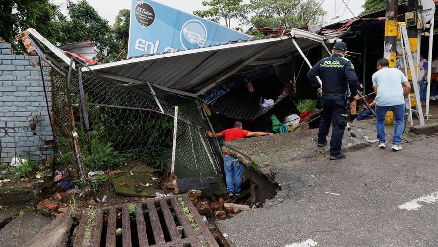Seorang pria menjaga barang-barang miliknya di jalan setelah hujan lebat di Villavicencio, Kolombia, 1 Juli 2025. (REUTERS/Santiago Molina Fernandez)