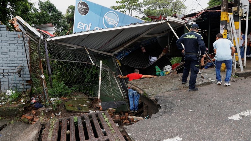 Seorang pria menjaga barang-barang miliknya di jalan setelah hujan lebat di Villavicencio, Kolombia, 1 Juli 2025. (REUTERS/Santiago Molina Fernandez)