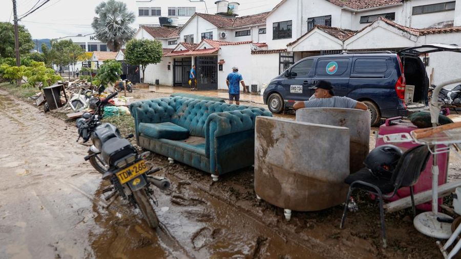 Seorang pria menjaga barang-barang miliknya di jalan setelah hujan lebat di Villavicencio, Kolombia, 1 Juli 2025. (REUTERS/Santiago Molina Fernandez)