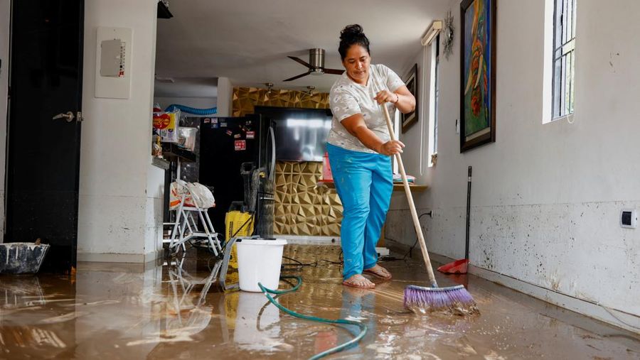 Seorang pria menjaga barang-barang miliknya di jalan setelah hujan lebat di Villavicencio, Kolombia, 1 Juli 2025. (REUTERS/Santiago Molina Fernandez)