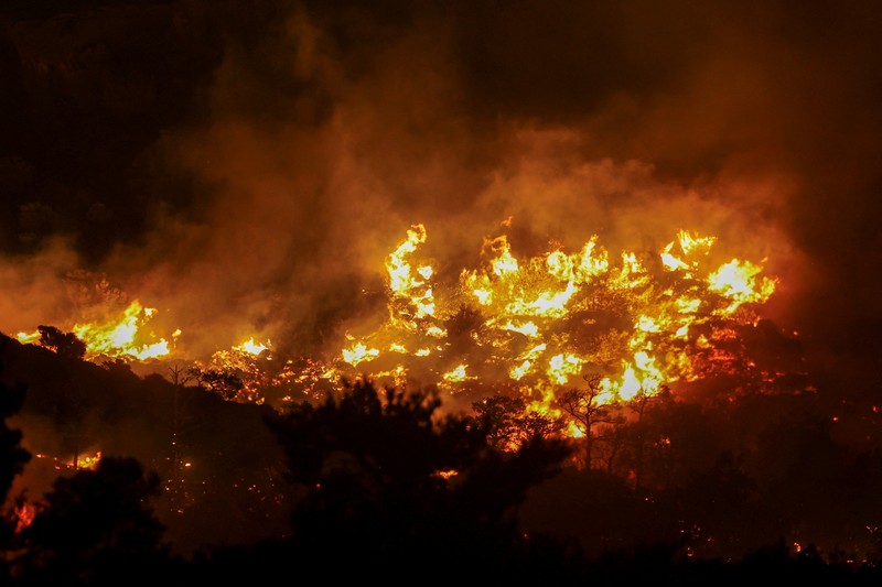 Api membubung saat kebakaran hutan melanda dekat Ierapetra, di Pulau Kreta, Yunani, 2 Juli 2025. (REUTERS/Stefanos Rapanis)