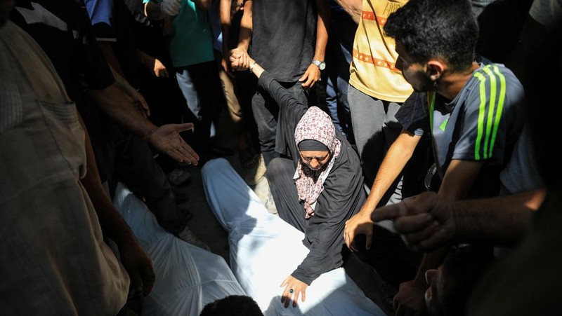 Warga Palestina bereaksi atas jenazah saat mereka berduka atas dokter Marwan al-Sultan, direktur Rumah Sakit Indonesia di Jalur Gaza utara, istrinya, putrinya dan saudara perempuannya, yang tewas dalam serangan Israel pada hari Rabu, menurut kementerian kesehatan Gaza, di rumah sakit Al-Shifa di Kota Gaza, 2 Juli 2025. (REUTERS/Mahmoud Issa)