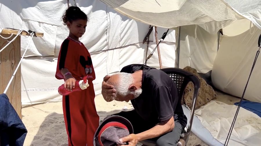 Seorang pria Palestina, yang mengungsi akibat serangan Israel, memandikan putranya di dalam tempat penampungan mereka di tengah teriknya musim panas, di Kota Gaza, 3 Juli 2025. Seorang pria Palestina, yang mengungsi akibat serangan Israel, memandikan putranya di dalam tempat penampungan mereka di tengah teriknya musim panas, di Kota Gaza, 3 Juli 2025. (REUTERS/Dawoud Abu Alkas)