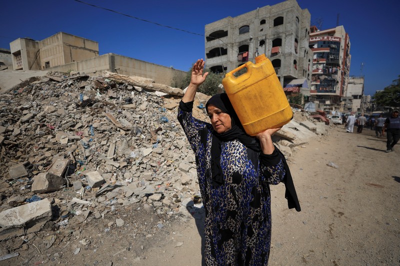 Seorang pria Palestina, yang mengungsi akibat serangan Israel, memandikan putranya di dalam tempat penampungan mereka di tengah teriknya musim panas, di Kota Gaza, 3 Juli 2025. Seorang pria Palestina, yang mengungsi akibat serangan Israel, memandikan putranya di dalam tempat penampungan mereka di tengah teriknya musim panas, di Kota Gaza, 3 Juli 2025. (REUTERS/Dawoud Abu Alkas)