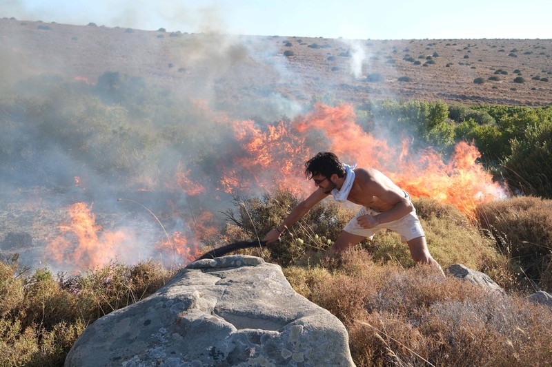 Seorang wanita bereaksi saat mencoba meninggalkan daerah tersebut dengan skuternya, selama kebakaran hutan di dekat Alacati, di provinsi Izmir, Turki, 3 Juli 2025. (REUTERS/Murat Kocabas)