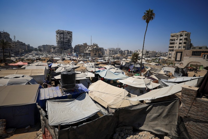 Seorang pria Palestina, yang mengungsi akibat serangan Israel, memandikan putranya di dalam tempat penampungan mereka di tengah teriknya musim panas, di Kota Gaza, 3 Juli 2025. Seorang pria Palestina, yang mengungsi akibat serangan Israel, memandikan putranya di dalam tempat penampungan mereka di tengah teriknya musim panas, di Kota Gaza, 3 Juli 2025. (REUTERS/Dawoud Abu Alkas)