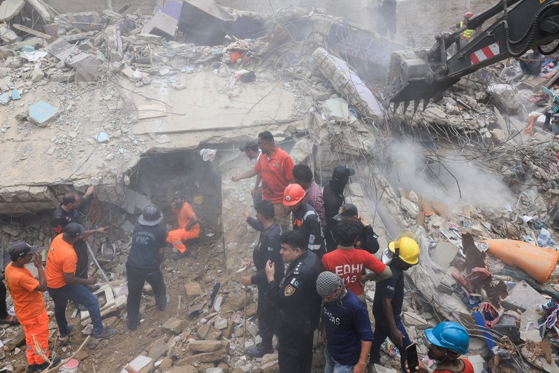 Petugas penyelamat mencari korban selamat saat mereka melewati reruntuhan bangunan tempat tinggal lima lantai yang runtuh di Karachi, Pakistan, 4 Juli 2025. (REUTERS/Akhtar Soomro)