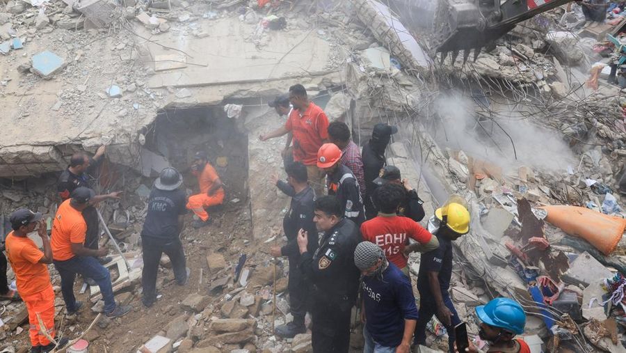 Petugas penyelamat mencari korban selamat saat mereka melewati reruntuhan bangunan tempat tinggal lima lantai yang runtuh di Karachi, Pakistan, 4 Juli 2025. (REUTERS/Akhtar Soomro)