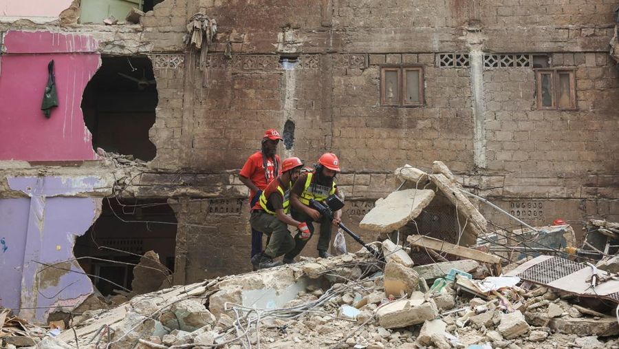 Petugas penyelamat mencari korban selamat saat mereka melewati reruntuhan bangunan tempat tinggal lima lantai yang runtuh di Karachi, Pakistan, 4 Juli 2025. (REUTERS/Akhtar Soomro)