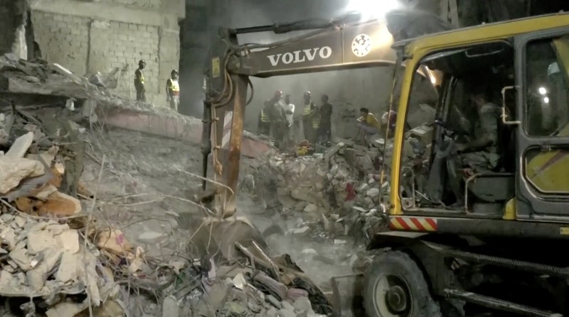 Petugas penyelamat mencari korban selamat saat mereka melewati reruntuhan bangunan tempat tinggal lima lantai yang runtuh di Karachi, Pakistan, 4 Juli 2025. (REUTERS/Akhtar Soomro)