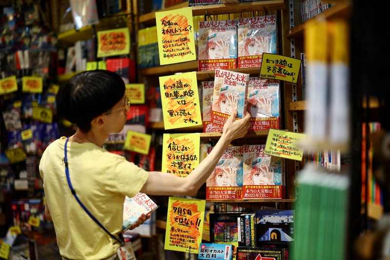 Seorang anggota staf meletakkan buku komik berjudul 'The Future I saw', yang ditulis oleh seniman manga Ryo Tatsuki, di rak toko buku Village Vanguard di Tokyo, Jepang, 30 Juni 2025. Seorang anggota staf meletakkan buku komik berjudul 'The Future I saw', yang ditulis oleh seniman manga Ryo Tatsuki, di rak toko buku Village Vanguard di Tokyo, Jepang, 30 Juni 2025. (REUTERS/Issei Kato)