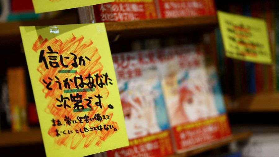 Spanduk penjualan yang ditulis oleh toko bertuliskan 'Percaya atau tidak, terserah Anda' dipajang di sebelah buku komik berjudul 'Masa Depan yang Kulihat', yang ditulis oleh seniman manga Ryo Tatsuki, di rak toko buku Village Vanguard di Tokyo, Jepang, 30 Juni 2025. (REUTERS/Issei Kato)