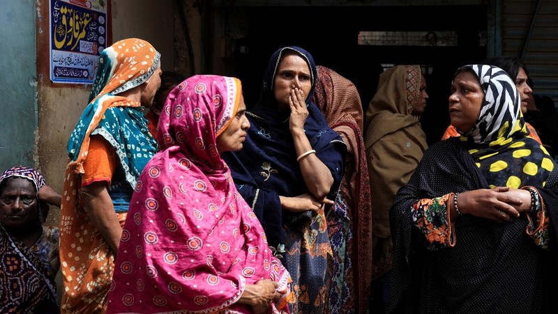Petugas penyelamat mencari korban selamat saat mereka melewati reruntuhan bangunan tempat tinggal lima lantai yang runtuh di Karachi, Pakistan, 4 Juli 2025. (REUTERS/Akhtar Soomro)