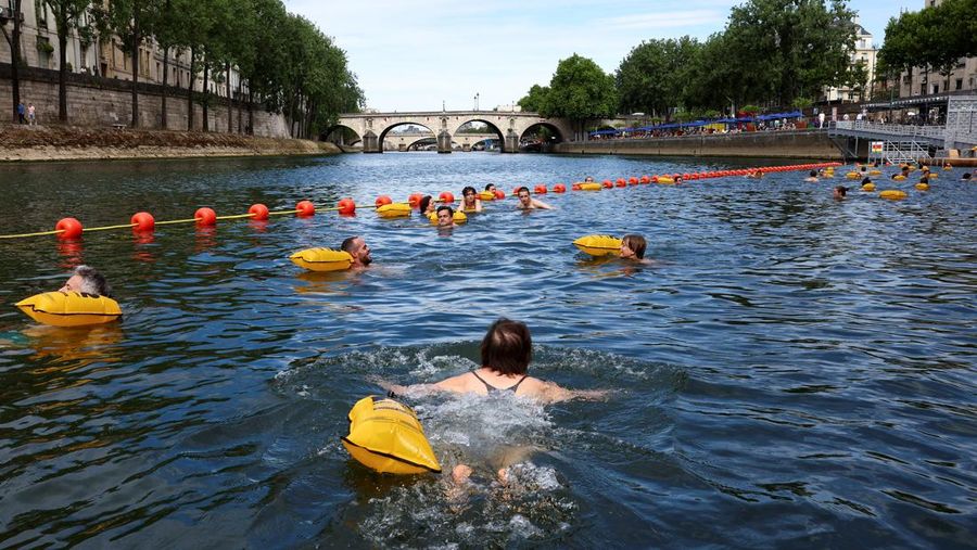 Orang-orang berenang di Sungai Seine di lokasi Bras Marie, dibuka untuk perenang yang menandai sesi pemandian umum pertama di jalur air bersejarah ibu kota, di Paris, Prancis, 5 Juli 2025. (Tangkapan Layar Video Reuters/)