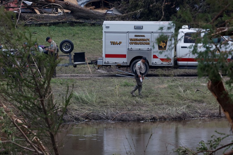 Tim penyelamat mendayung perahu karet saat mencari korban setelah banjir bandang di Kerrville, Texas, AS, Minggu (6/7/2025). (REUTERS/Marco Bello)