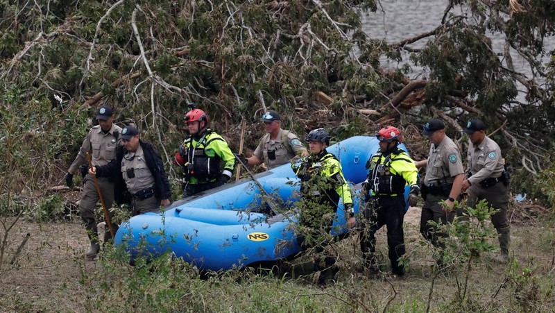 Tim penyelamat mendayung perahu karet saat mencari korban setelah banjir bandang di Kerrville, Texas, AS, Minggu (6/7/2025). (REUTERS/Marco Bello)