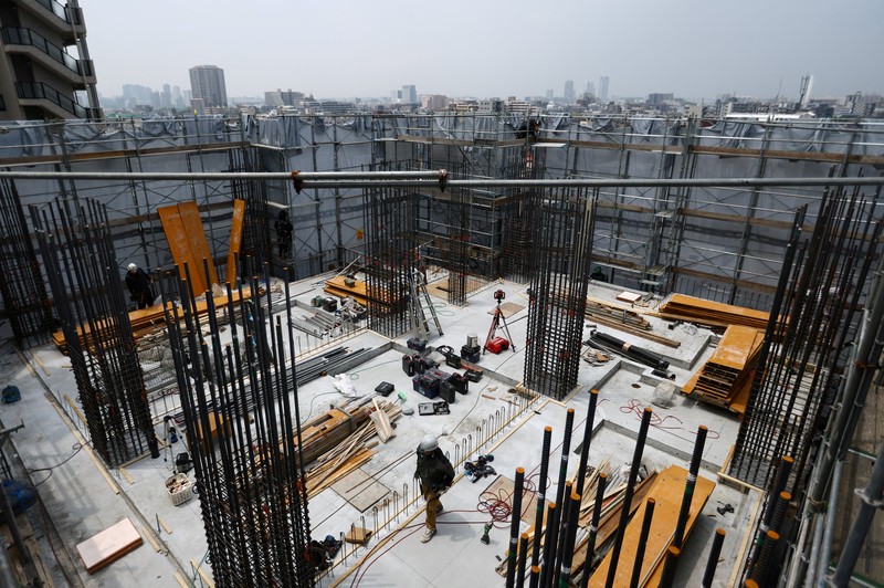 ASIA-WEATHER/JAPAN-HEATWAVE Heat-exposed workers, wearing air-conditioned jackets, which have cooling fans on their backs, are seen at the top of an apartment building under construction, as the Japanese government issued a heatstroke alert in Tokyo and other prefectures, in Tokyo, Japan, July 7, 2025. REUTERS/Issei Kato