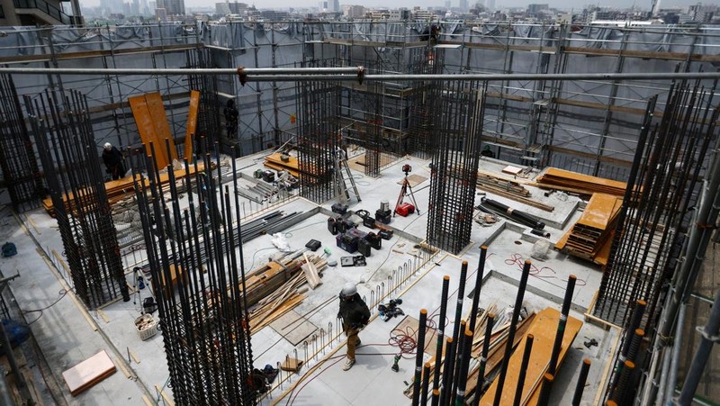 Heat-exposed workers, wearing air-conditioned jackets, which have cooling fans on their backs, are seen at the top of an apartment building under construction, as the Japanese government issued a heatstroke alert in Tokyo and other prefectures, in Tokyo, Japan, July 7, 2025. REUTERS/Issei Kato