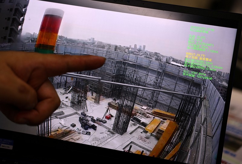ASIA-WEATHER/JAPAN-HEATWAVE Heat-exposed workers, wearing air-conditioned jackets, which have cooling fans on their backs, are seen at the top of an apartment building under construction, as the Japanese government issued a heatstroke alert in Tokyo and other prefectures, in Tokyo, Japan, July 7, 2025. REUTERS/Issei Kato