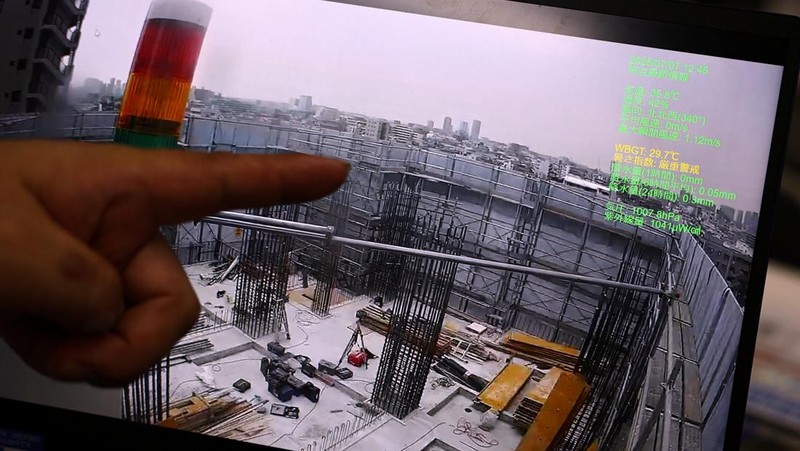 Heat-exposed workers, wearing air-conditioned jackets, which have cooling fans on their backs, are seen at the top of an apartment building under construction, as the Japanese government issued a heatstroke alert in Tokyo and other prefectures, in Tokyo, Japan, July 7, 2025. REUTERS/Issei Kato