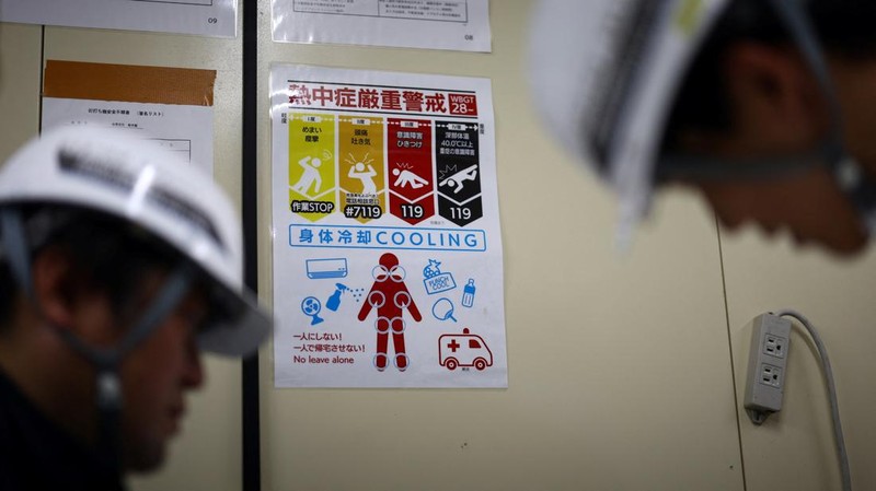 Heat-exposed workers, wearing air-conditioned jackets, which have cooling fans on their backs, are seen at the top of an apartment building under construction, as the Japanese government issued a heatstroke alert in Tokyo and other prefectures, in Tokyo, Japan, July 7, 2025. REUTERS/Issei Kato