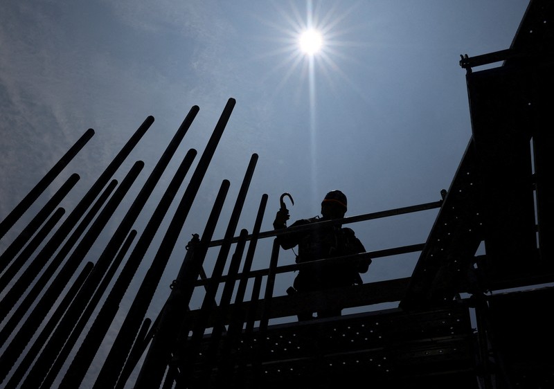ASIA-WEATHER/JAPAN-HEATWAVE Heat-exposed workers, wearing air-conditioned jackets, which have cooling fans on their backs, are seen at the top of an apartment building under construction, as the Japanese government issued a heatstroke alert in Tokyo and other prefectures, in Tokyo, Japan, July 7, 2025. REUTERS/Issei Kato