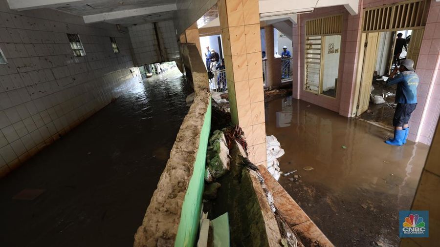 Petugas Penanganan Prasarana dan Sarana Umum (PPSU) dan Sumber Daya Air langsung melakukan penanganan awal tanggul jebol di Jati Padang, Pasar Minggu, Jakarta Selatan, Senin (7/7/2025). (CNBC Indonesia/Tri Susilo)