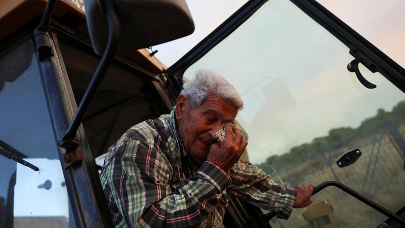 Anak-anak menyaksikan helikopter terbang untuk membantu memadamkan kebakaran hutan yang terjadi di Xerta, salah satu desa terkurung di provinsi Tarragona di Catalonia, Spanyol, 8 Juli 2025. (REUTERS/Nacho Doce)