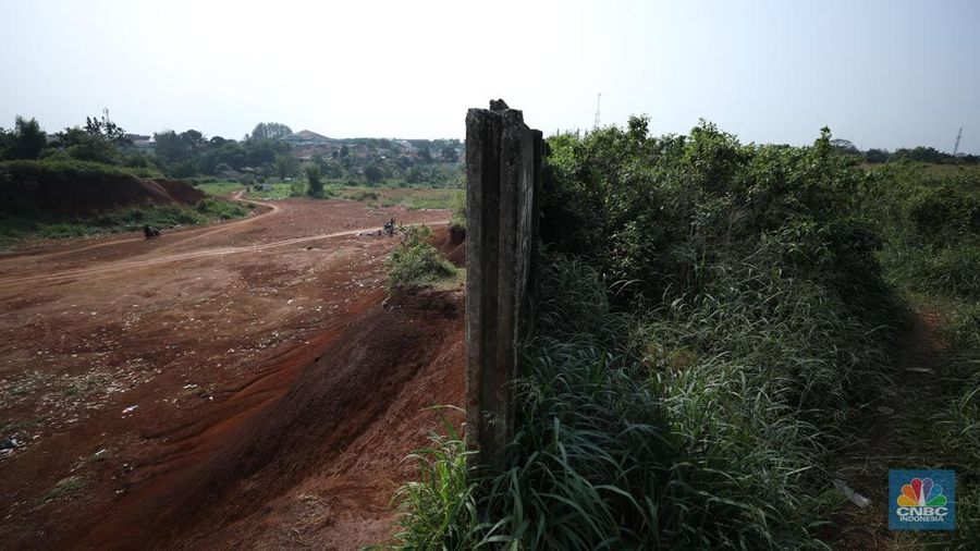 Warga melintasi Tanah Merah dengan sepeda motor di kawasan Cipayung, Depok, Jawa Barat, Rabu (9/7/2025). (CNBC Indonesia/Tri Susilo)