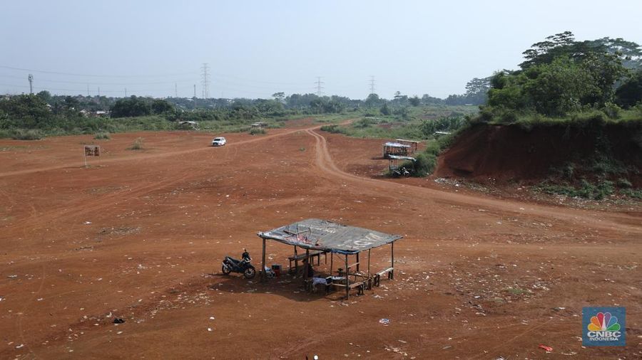 Warga melintasi Tanah Merah dengan sepeda motor di kawasan Cipayung, Depok, Jawa Barat, Rabu (9/7/2025). (CNBC Indonesia/Tri Susilo)