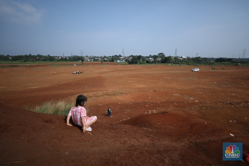 Warga melintasi Tanah Merah dengan sepeda motor di kawasan Cipayung, Depok, Jawa Barat, Rabu (9/7/2025). Warga melintasi Tanah Merah dengan sepeda motor di kawasan Cipayung, Depok, Jawa Barat, Rabu (9/7/2025). (CNBC Indonesia/Tri Susilo)