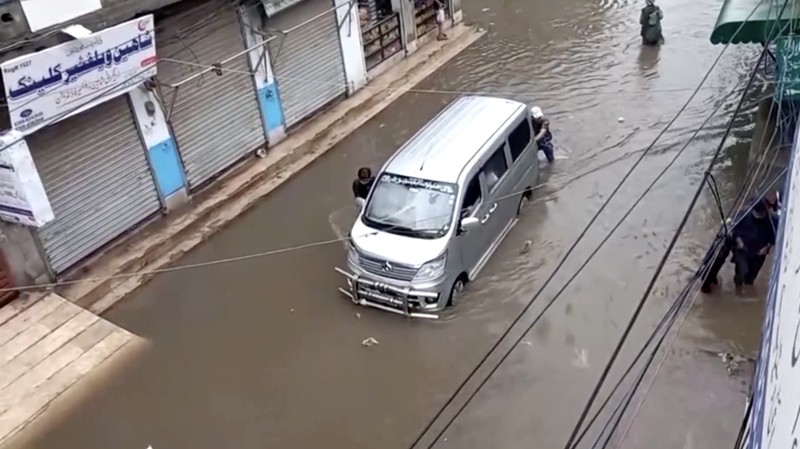 Seseorang mengendarai sepeda motor melewati jalan yang banjir setelah hujan deras di Lahore, Pakistan, 9 Juli 2025. (REUTERS/Mohsin Raza)
