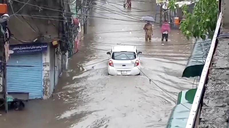 Seseorang mengendarai sepeda motor melewati jalan yang banjir setelah hujan deras di Lahore, Pakistan, 9 Juli 2025. (REUTERS/Mohsin Raza)