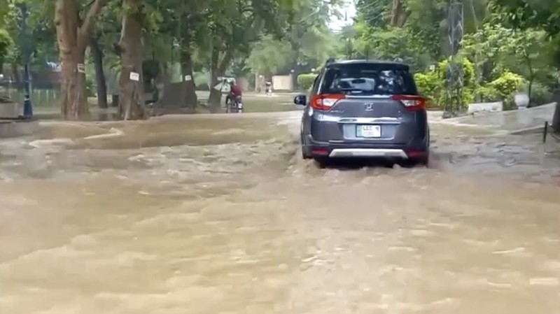 Seseorang mengendarai sepeda motor melewati jalan yang banjir setelah hujan deras di Lahore, Pakistan, 9 Juli 2025. (REUTERS/Mohsin Raza)