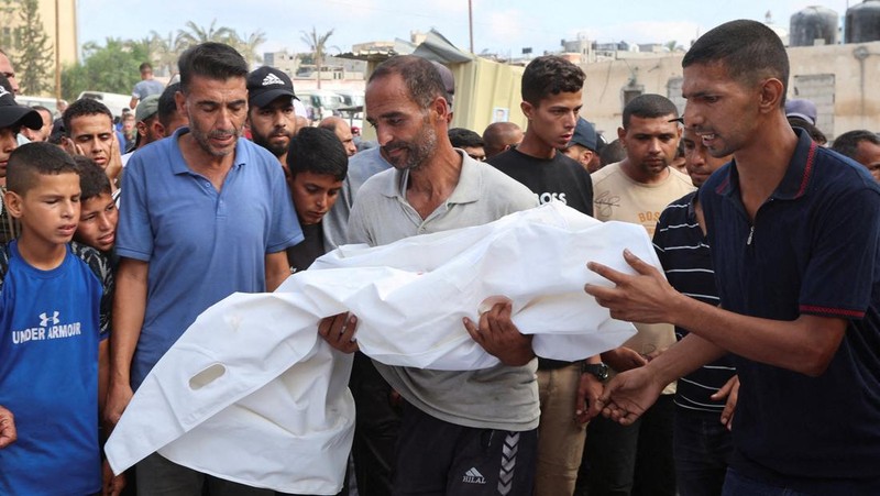 Palestinian children inspect the damage at the site of an overnight Israeli airstrike that hit a tent sheltering displaced people, in Khan Younis, southern Gaza Strip, July 12, 2025. REUTERS/Ramadan Abed