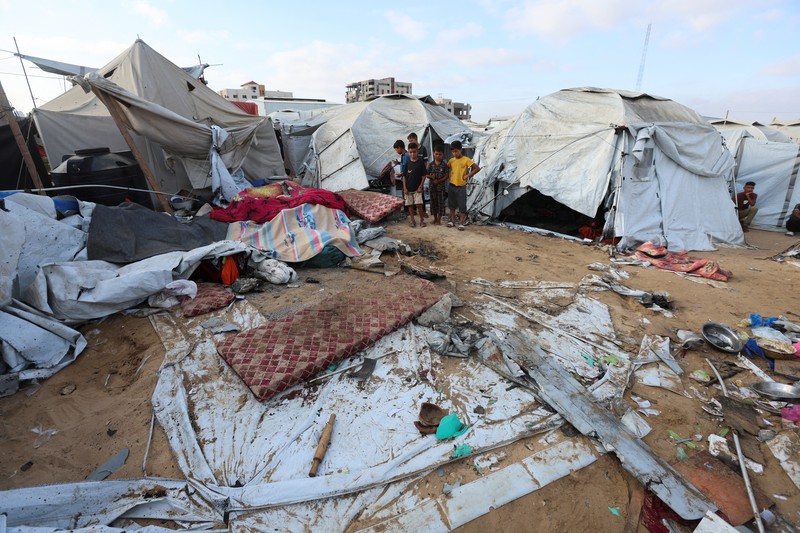 ISRAEL-PALESTINIANS/GAZA Palestinian children inspect the damage at the site of an overnight Israeli airstrike that hit a tent sheltering displaced people, in Khan Younis, southern Gaza Strip, July 12, 2025. REUTERS/Ramadan Abed
