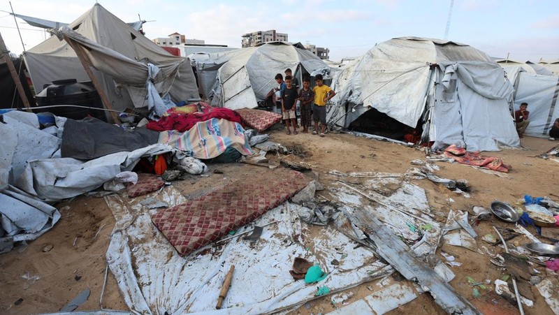 Palestinian children inspect the damage at the site of an overnight Israeli airstrike that hit a tent sheltering displaced people, in Khan Younis, southern Gaza Strip, July 12, 2025. REUTERS/Ramadan Abed