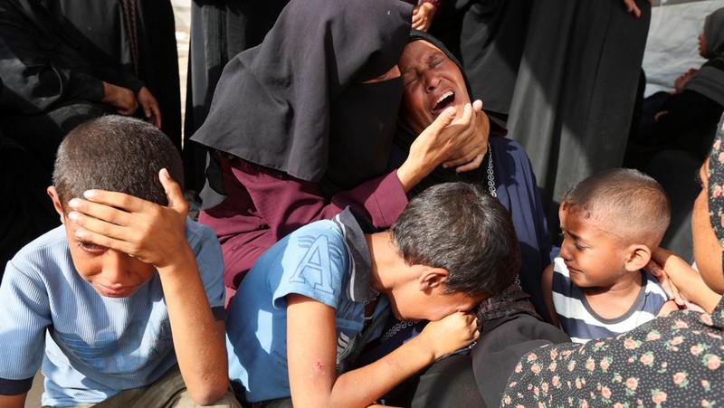 Palestinian children inspect the damage at the site of an overnight Israeli airstrike that hit a tent sheltering displaced people, in Khan Younis, southern Gaza Strip, July 12, 2025. REUTERS/Ramadan Abed