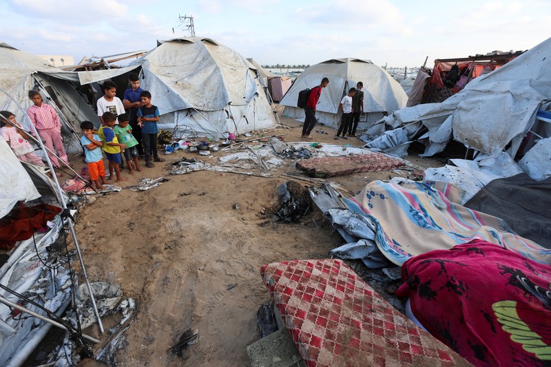 ISRAEL-PALESTINIANS/GAZA Palestinian children inspect the damage at the site of an overnight Israeli airstrike that hit a tent sheltering displaced people, in Khan Younis, southern Gaza Strip, July 12, 2025. REUTERS/Ramadan Abed