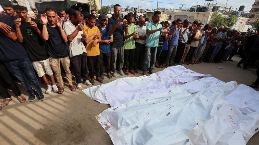 Palestinian children inspect the damage at the site of an overnight Israeli airstrike that hit a tent sheltering displaced people, in Khan Younis, southern Gaza Strip, July 12, 2025. REUTERS/Ramadan Abed