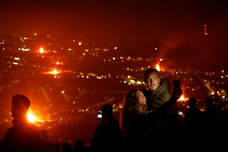 MIGRATION-NIRELAND/ A loyalist bonfire burns after being set alight, featuring a model effigy of a boat containing mannequins portrayed as migrants in lifejackets, with a sign reading