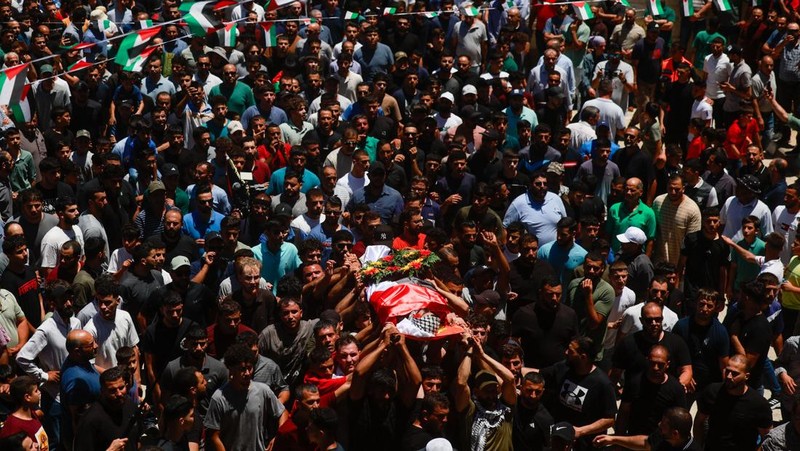 Orang-orang membawa jenazah Sayfollah Kamel Musallet, seorang pria Palestina-Amerika yang dipukuli hingga tewas oleh para pemukim, menurut Kementerian Kesehatan Palestina, dalam pemakamannya di dekat Ramallah, di Tepi Barat yang diduduki Israel, 13 Juli 2025. REUTERS/Ammar Awad